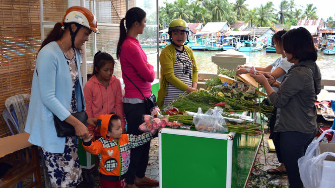Người dân đến gian hàng mua ủng hộ hoạt động của nhóm bạn trẻ - Ảnh: H.TRUNG