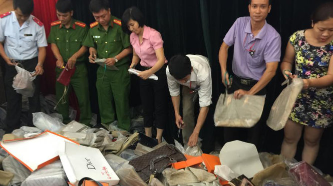 Lực lượng chức năng tiêu hủy hàng giả sáng 21-10 - Ảnh: Thanh Hà