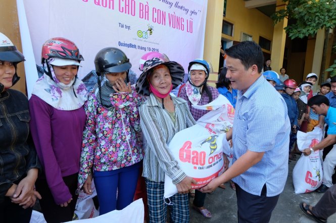 Ông Nguyễn Văn Nghệ, phó tổng giám đốc nhà máy phân bón Ong Biển trao quà cho người dân vùng lũ Quảng Trường, huyện Quảng Trạch, Quảng Bình chiều 28-10 - Ảnh: QUỐC NAM
