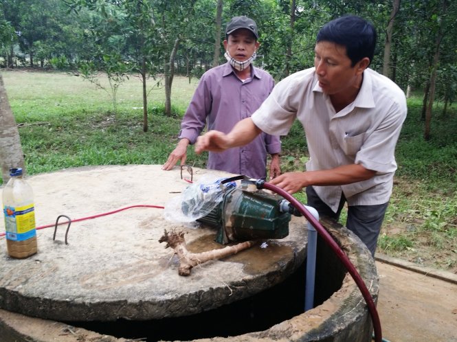 Thầy Thái Bình Giảng (bên trái) đang cùng với các thầy cô của Trường tiêu học Trần Quốc Toản (xã Cam tuyền, huyện Cam Lộ) dọn vệ sinh sau trận lũ hôm 1-11. Ảnh: NHẬT LINH