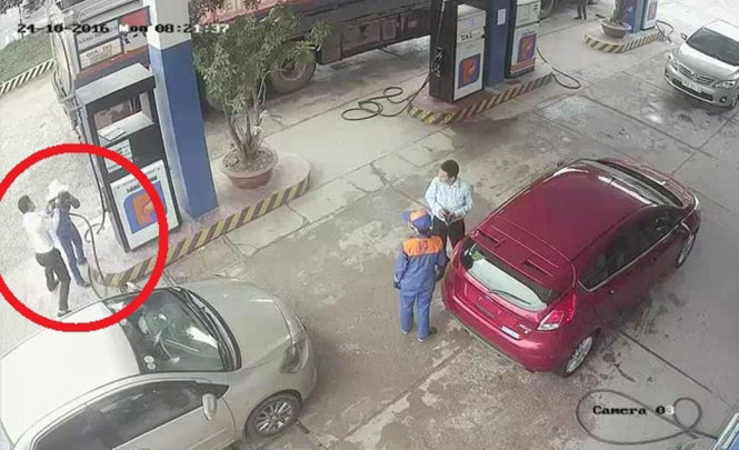 Hình ảnh ông Đức dùng cò bơm xăng đánh chị Ng. được camera cây xăng ghi lại - Ảnh: D.HÒA chụp màn hình