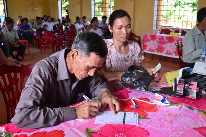 Những ngư dân đầu tiên tại xã Vĩnh Thạch nhận tiền đền bù từ Formosa ngày 16-11 – Ảnh: QUỐC NAM