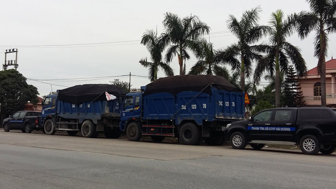 Lực lượng thanh tra giao thông Hải Dương phải dùng xe công vụ để chặn đầu, chặn đuôi hai phương tiện quá tải không để các xe này tẩu thoát - Ảnh: CTV