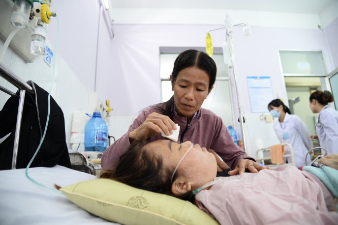 Sau sáu năm làm trụ cột gia đình, nay Liên nằm bất động. Mẹ bươn bả từ Quảng Ngãi vào chăm sóc con gái tại phòng bệnh nặng, khoa nội  - Bệnh viện Thủ Đức (TP.HCM) sáng 24-11 - Ảnh: TỰ TRUNG