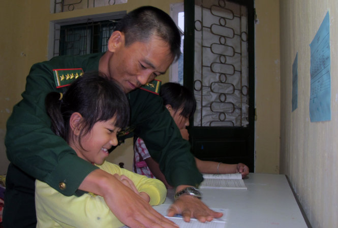 “Bố nuôi” - đại úy Vàng Khai Phòng, đội vận động quần chúng đồn biên phòng Phó Bảng (Hà Giang), uốn nắn tư thế ngồi cho các con nuôi của đồn - Ảnh: Đ.BÌNH