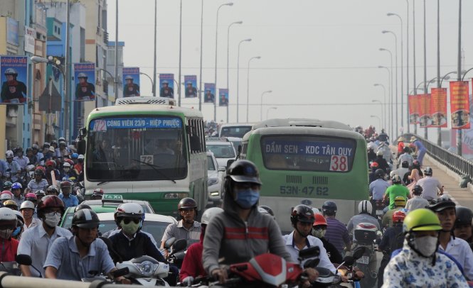 Số người đi xe buýt giảm do nhiều nguyên nhân như chất lượng kém, hạ tầng chưa phát triển... Trong ảnh: xe buýt bị bao vây bởi các phương tiện khác dưới chân cầu Kênh Tẻ (Q.4, TP.HCM) - Ảnh: TỰ TRUNG