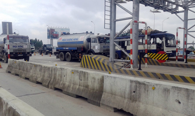 Các xe bồn của Công ty CP Nhựa đường Minh Đạt đỗ trên các làn đường của trạm thu phí Nam Bình Định hồi 11g trưa 10-12 - Ảnh: BÌNH HÀ