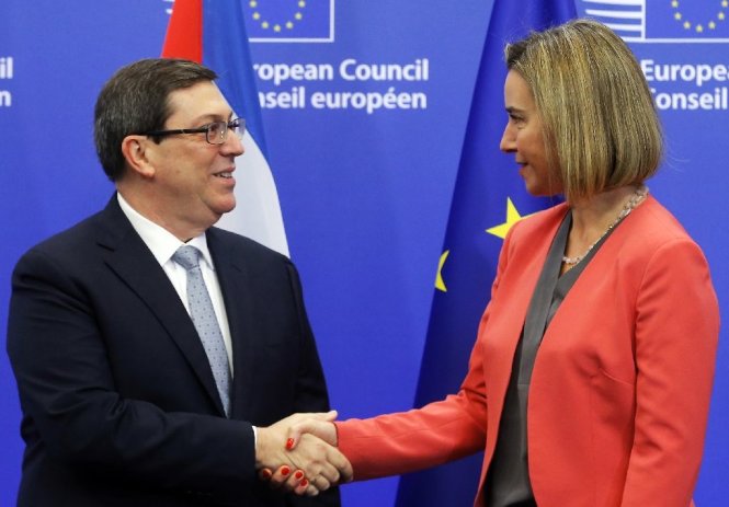 Bộ trưởng ngoại giao Cuba Bruno Rodriguez Parrilla (trái) và đại diện phụ trách ngoại giao của EU Federica Mogherini bắt tay nhau trong lễ ký kết thỏa thuận bình thường hóa quan hệ tại Brussels ngày 12-12-2016 - Ảnh: AFP
