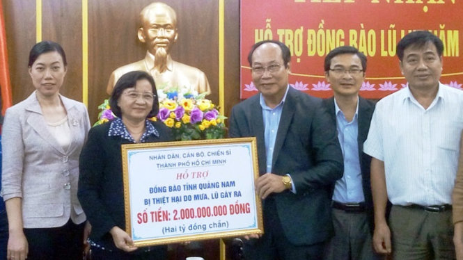 Bà Thân Thị Thư - trưởng ban tuyên giáo Thành ủy TP.HCM trao số tiền 2 tỉ đồng hỗ trợ người dân vùng lũ - Ảnh: L.T