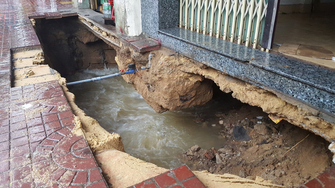 Hàm ếch rất lớn dưới nền móng hai ngôi nhà, dòng nước phụt ra rất mạnh cuốn trôi đất đá làm hổng chân nhà - Ảnh: DUY THANH