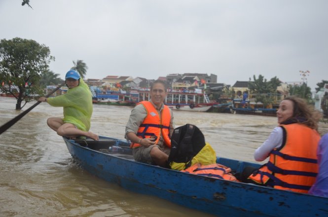 Một số du khách đứng trên chùa Cầu ngắm lũ - Ảnh: Thanh Ba