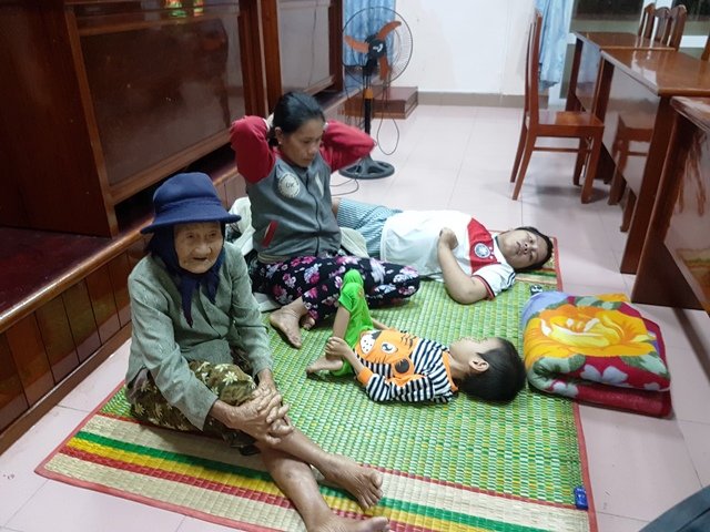 Người già, phụ nữ và trẻ em ở vùng nguy hiểm thuộc thôn Trung Tín 1 và xóm lò vôi ở thôn Phong Thạnh – thị trấn Tuy Phước được chính quyền địa phương di dời về trụ sở UBND thị trấn Tuy Phước trú ẩn trong tối ngày 15.12 - Ảnh: Xuân Vinh