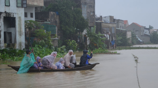 Đi trong lũ nhưng không mang áo phao là nguy cơ đe doa tính mạng rất cao. Ảnh chụp tại thị xã Điện Bàn  - Ảnh: TẤN LỰC