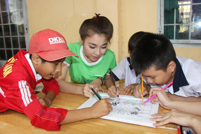 Văn nghệ sĩ cùng tô tranh với các học sinh - Ảnh: C.K.