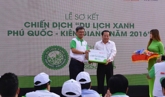 Nhà báo Đỗ Văn Dũng (bìa trái), Phó tổng Biên tập báo Tuổi Trẻ trao tặng bộ tài liệu của chương trình Du lịch xanh cho ông Mai Văn Huỳnh – Phó chủ tịch UBND tỉnh Kiên Giang. Ảnh: K.Nam.