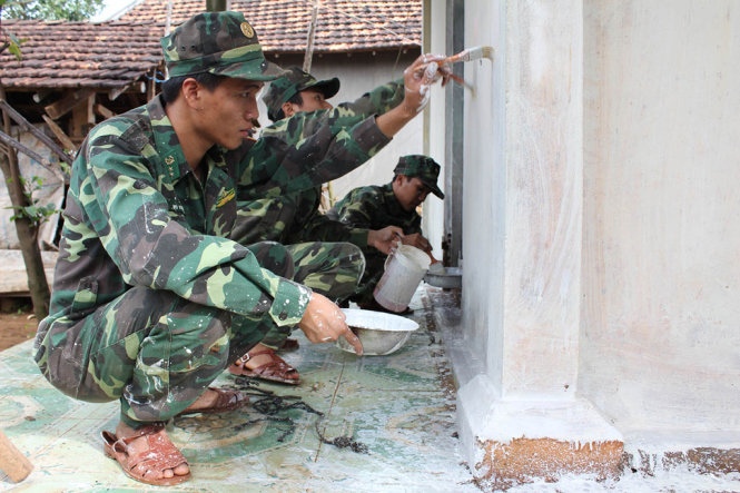 Chiến sĩ Hải đội Biên phòng 2 giúp dân sửa nhà đón tết - Ảnh: T.M.