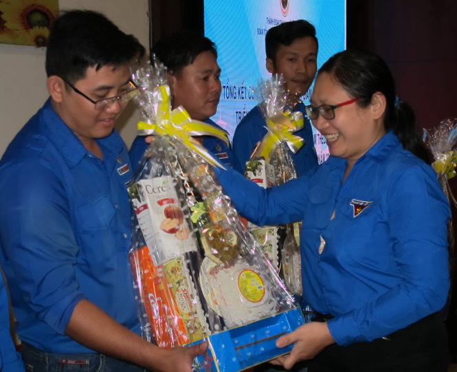Chị Hồ Thị Đan Thanh, chánh văn phòng Thành đoàn TP.HCM, trao quà Tết đến thợ điện trẻ khó khăn - Ảnh: K.ANH