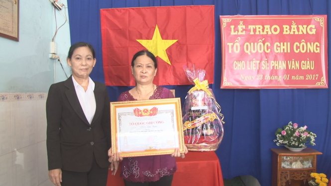 Trao bằng cho gia đình ông Phan Văn Giàu - Ảnh: Long Sa