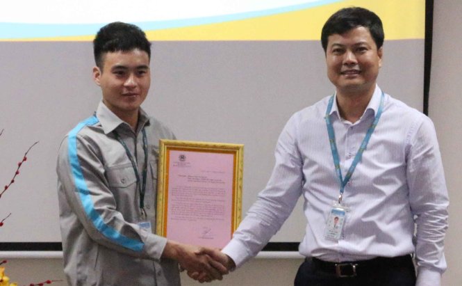 Ông Bùi Văn Thanh, Giám đốc Viags chi nhánh Tân Sơn Nhất trao thư khen của Bộ trưởng Bộ GTVT cho anh Trần Văn Nguyên chiều 25-1 - Ảnh: Đậu Đạt