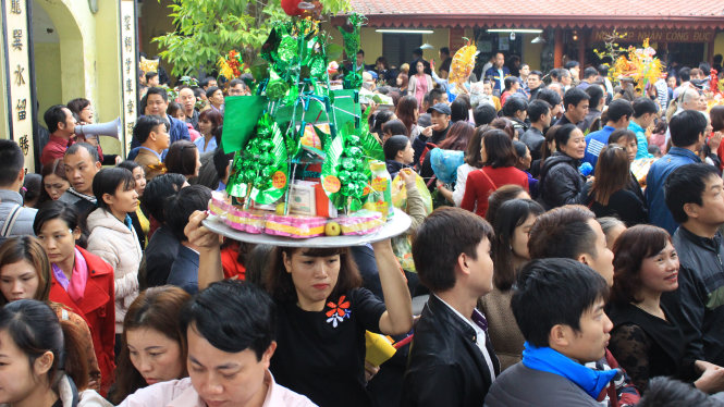 Dòng người kéo đến đông nghịt nên người dân phải bê mâm lễ lên cao tránh tình trạng xô đẩy - Ảnh: Hà Thanh