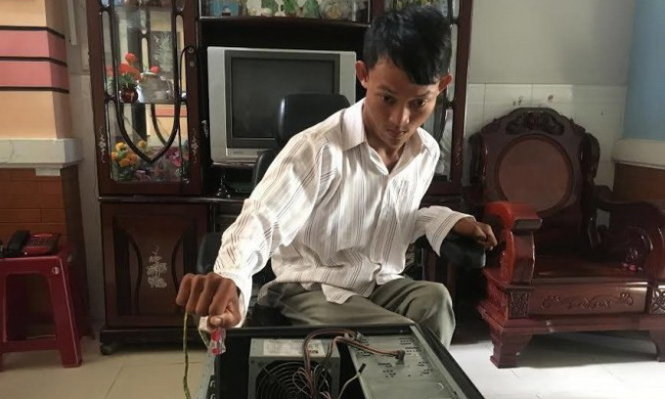 Ngọc Hiếu chăm chú sửa chữa máy tính cho khách hàng - Ảnh: NVCC