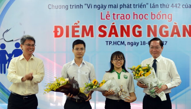 Ông Đỗ Văn Dũng - Phó tổng biên tập báo Tuổi Trẻ tặng hoa cho các khách mời giao lưu trong lễ trao học bổng Điểm sáng ngành y tại TP.HCM chiều 18-2 - Ảnh: DUYÊN PHAN