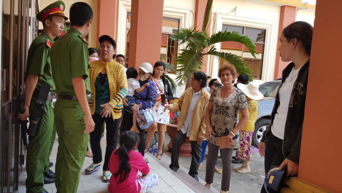 Người nhà bị hại dùng trẻ em để gây áp lực với lực lượng cảnh sát bảo vệ bên hành lang phòng xử - Ảnh: K.Nam