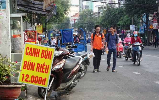 Vỉa hè đường D2, Q.Bình Thạnh (TP.HCM) bị các hộ kinh doanh lấn chiếm nên người đi bộ phải đi xuống lòng đường  - Ảnh: Duyên Phan