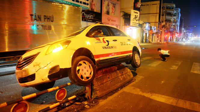 Chiếc taxi nằm gọn trên dãi phân cách sau cú lao - Ảnh: HỮU KHOA