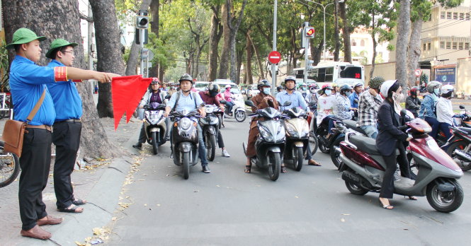 Các bạn trẻ đội tình nguyện phản ứng nhanh Q.1 (TP.HCM) trực tại ngã tư Tôn Đức Thắng - Nguyễn Hữu Cảnh giờ cao điểm chiều 1-3 - Ảnh: Q.L.