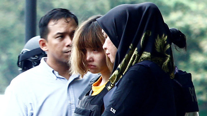 Cảnh sát dẫn giải Đoàn Thị Hương (giữa) sau phiên công bố cáo trạng tại Malaysia - Ảnh: Reuters
