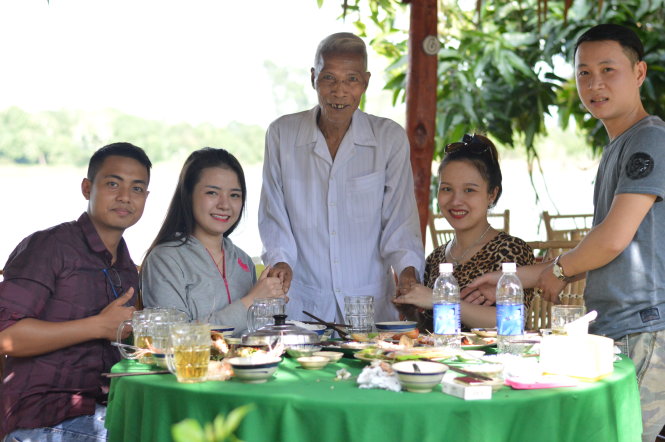 Ông Lê Văn Thành (giữa) thăm hỏi sự hài lòng của du khách khi đến điểm du lịch của ông - Ảnh: NGỌC TÀI