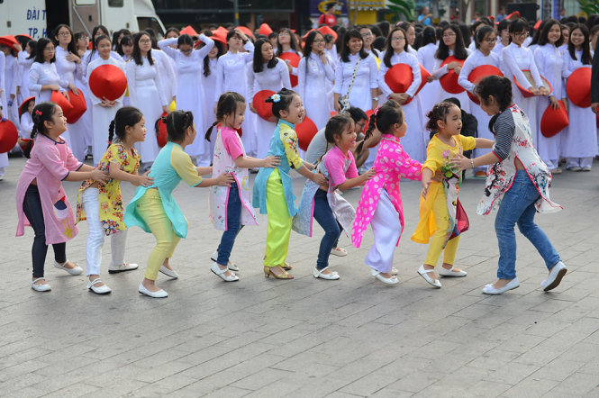 Các em nhỏ vui chơi trong tà áo dài - Ảnh: QUANG ĐỊNH
