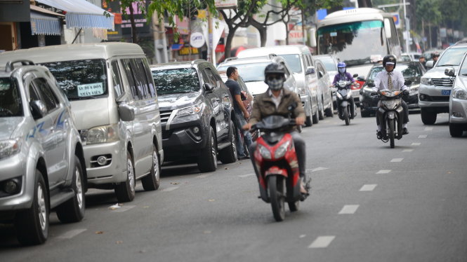Tại khu vực trung tâm TP.HCM ngoài tình trạng người dân đậu xe không phép, một số lòng đường cũng
được cho phép đậu xe. Trong ảnh: ôtô đậu dưới lòng đường ở TP.HCM - Ảnh: QUANG ĐỊNH