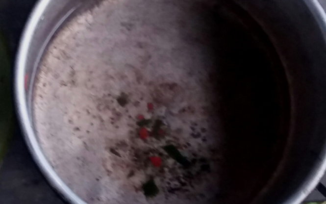 Trứng nghi là trứng cóc được phát hiện trong đáy nồi của gia đình em Hồ Văn Nam sót lại sau khi sự việc xảy ra - Ảnh: Q.H