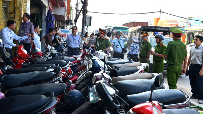 Một hộ kinh doanh để xe tràn ra vỉa hè bị lực lượng chức năng xử phạt - Ảnh: Lê Phan