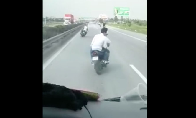 Ảnh trích từ clip cho thấy các xe máy lạng lách trước đầu ô tô trên một quãng đường dài