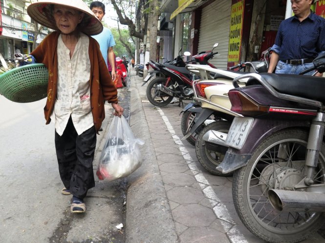 Đường dành cho người đi bộ chỉ còn một hàng gạch trên vỉa hè khiến người đi bộ phải đi xuống lòng đường - Ảnh: Hoàng Bách