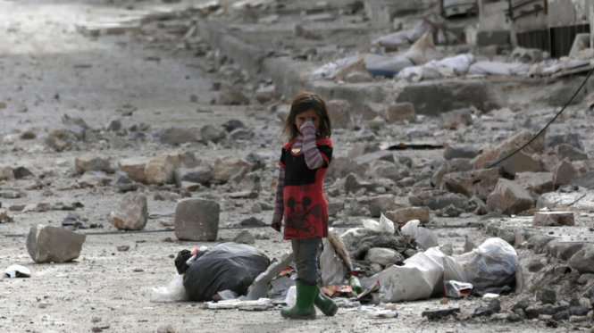 Hơn 320.000 người đã bị sát hại tại Syria kể từ khi chiến sự nổ ra từ sáu năm trước. Một bé gái đứng giữa đống đổ nát của các tòa nhà bị bom phá hủy ở thị trấn al-Bab phía bắc Syria ngày 28-2-2017 - Ảnh: Reuters