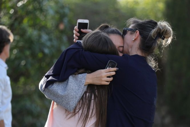 Mọi người ôm nhau sau vụ xả súng khiến 8 người bị thương ở Grasse - Ảnh: AFP
