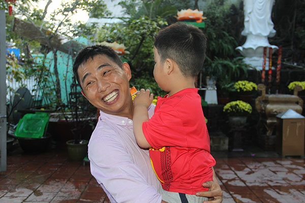 Lê Văn Ánh và một đứa trẻ mà anh cưu mang - Ảnh: TRƯỜNG TRUNG