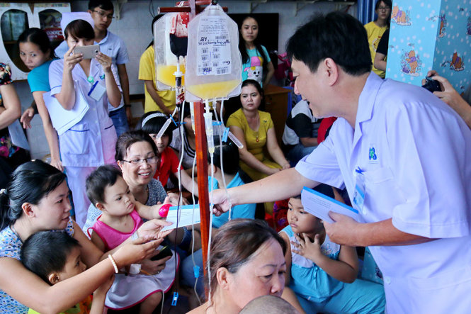TS.BSCKII Phạm Xuân Dũng, giám đốc Bệnh viện Ung bướu TP.HCM trao tiền hỗ trợ cho các bệnh nhi ung thư - Ảnh: NGỌC HIỂN