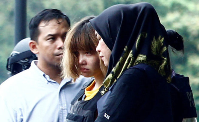 Cảnh sát dẫn giải Đoàn Thị Hương (giữa) sau phiên công bố cáo trạng tại Malaysia - Ảnh: Reuters