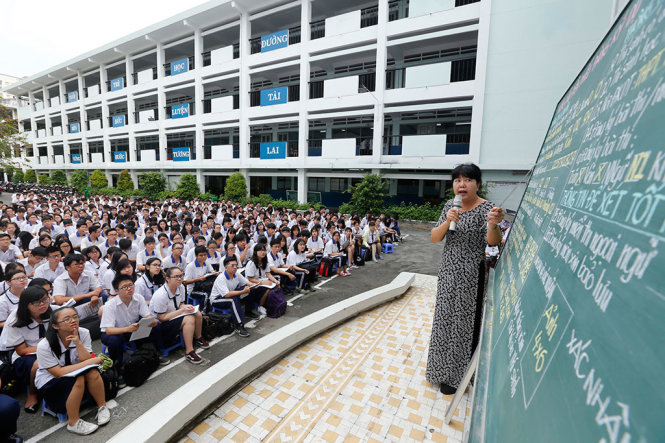 Cô Huỳnh Thị Bích Vân, giáo viên phụ trách học vụ Trường THPT Nguyễn An Ninh, Q.10, TP.HCM, hướng dẫn học sinh khối 12 cách ghi hồ sơ dự thi kỳ thi THPT quốc gia năm 2017, sáng 3-4 - Ảnh: NHƯ HÙNG
