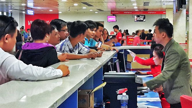 Theo các chuyên gia, việc áp giá sàn có thể tiêu diệt hãng hàng không giá rẻ và làm giảm khả năng đi lại của người dân. Trong ảnh: Khách lấy vé lên máy bay của một hãng hàng không giá rẻ - Ảnh: Hữu Khoa
