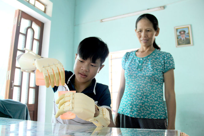 Em Phan Trọng Hiếu dùng “đôi bàn tay mơ ước” pha nước mời mẹ - Ảnh: TRƯỜNG TRUNG