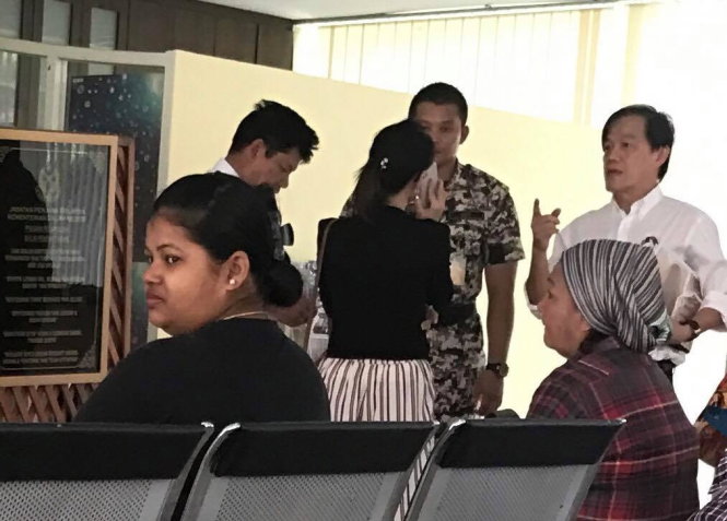 Ông Đoàn Văn Thạnh (bìa trái) - cha nghi phạm Đoàn Thị Hương, đại diện của Đại sứ quán Việt Nam (người phụ nữ đứng giữa) và luật sư Teh Poh Teik (bìa phải) chờ vào thăm Đoàn Thị Hương sáng 12-4-Ảnh: QUỲNH TRUNG