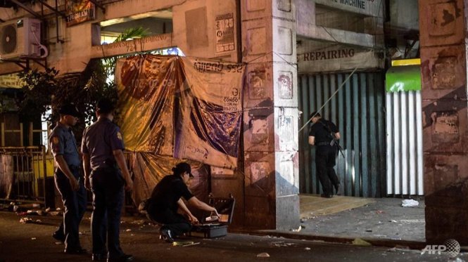 Nhân viên cảnh sát đang điều tra hiện trường vụ nổ ở Quiapo, Manila ngày 28-4 - Ảnh: AFP