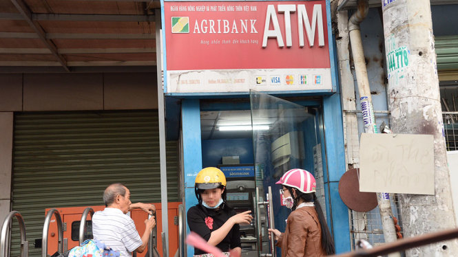 Nhiều người tranh thủ giao dịch trên ATM vào ban ngày, tránh bị gián đoạn khi ATM ngừng giao dịch vào ban đêm - Ảnh: TỰ TRUNG