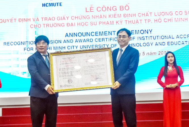 PGS.TS Nguyễn Hội Nghĩa (phải) trao quyết định và trao giấy chứng nhận kiểm định chất lượng cơ sở giáo dục cho PGS.TS Đỗ Văn Dũng - hiệu trưởng Trường ĐH Sư phạm kỹ thuật TP.HCM - Ảnh: T.Linh